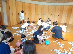 ビニール袋に新聞を詰めてカエルとうさぎを作るようす